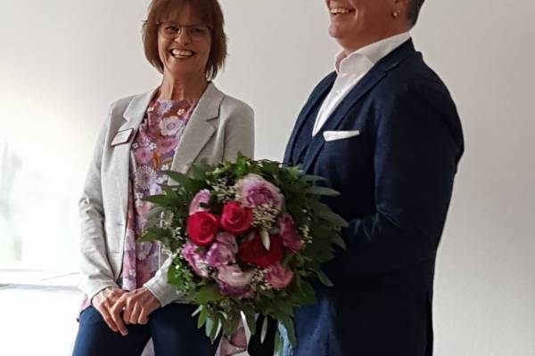 Annegret Heuschmid freut sich über 25 Jahre ASB Therapiezentrum. Ralf Kinzler überreicht in Vertretung von Michael Bitterle einen Blumenstrauß.