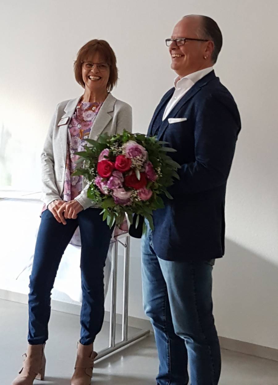 Annegret Heuschmid freut sich über 25 Jahre ASB Therapiezentrum. Ralf Kinzler überreicht in Vertretung von Michael Bitterle einen Blumenstrauß.